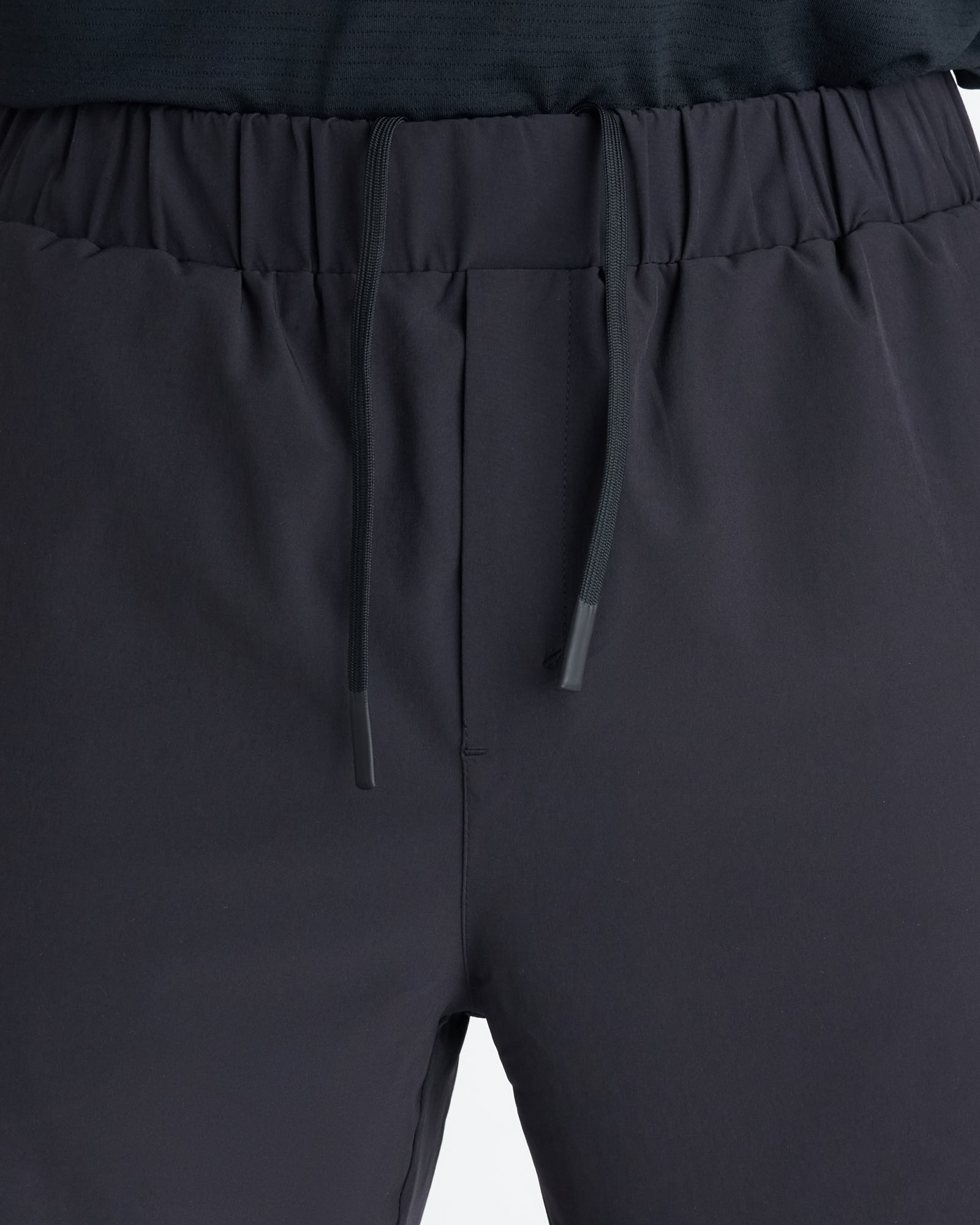 Close-up of the black Pulse Tech Linerless Short waistband, showing elastic band, drawstring, and clean front panel.