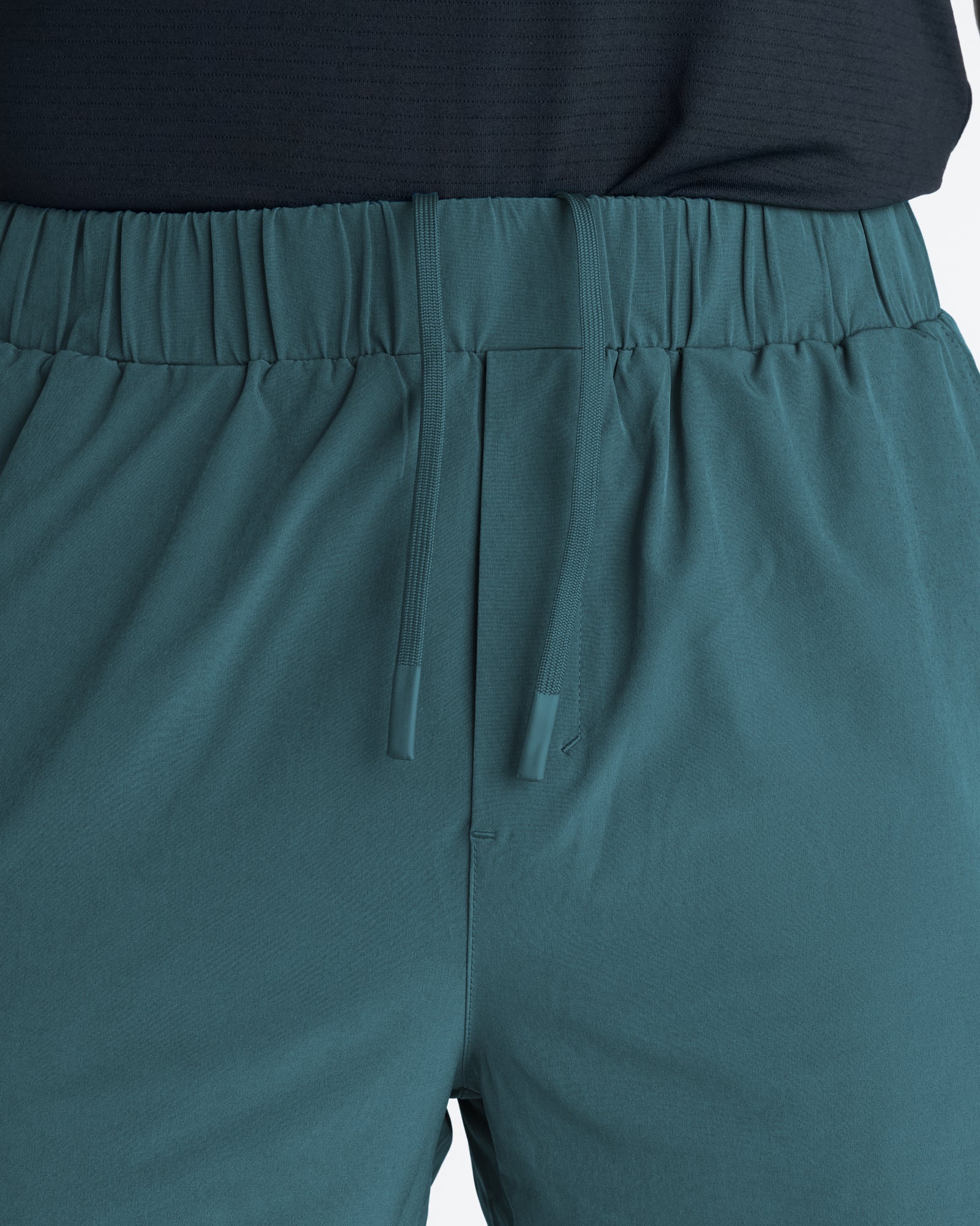 Close-up of Pulse Tech Linerless Short in Teal showing elastic waistband, tonal drawstring, and hidden pocket detail.