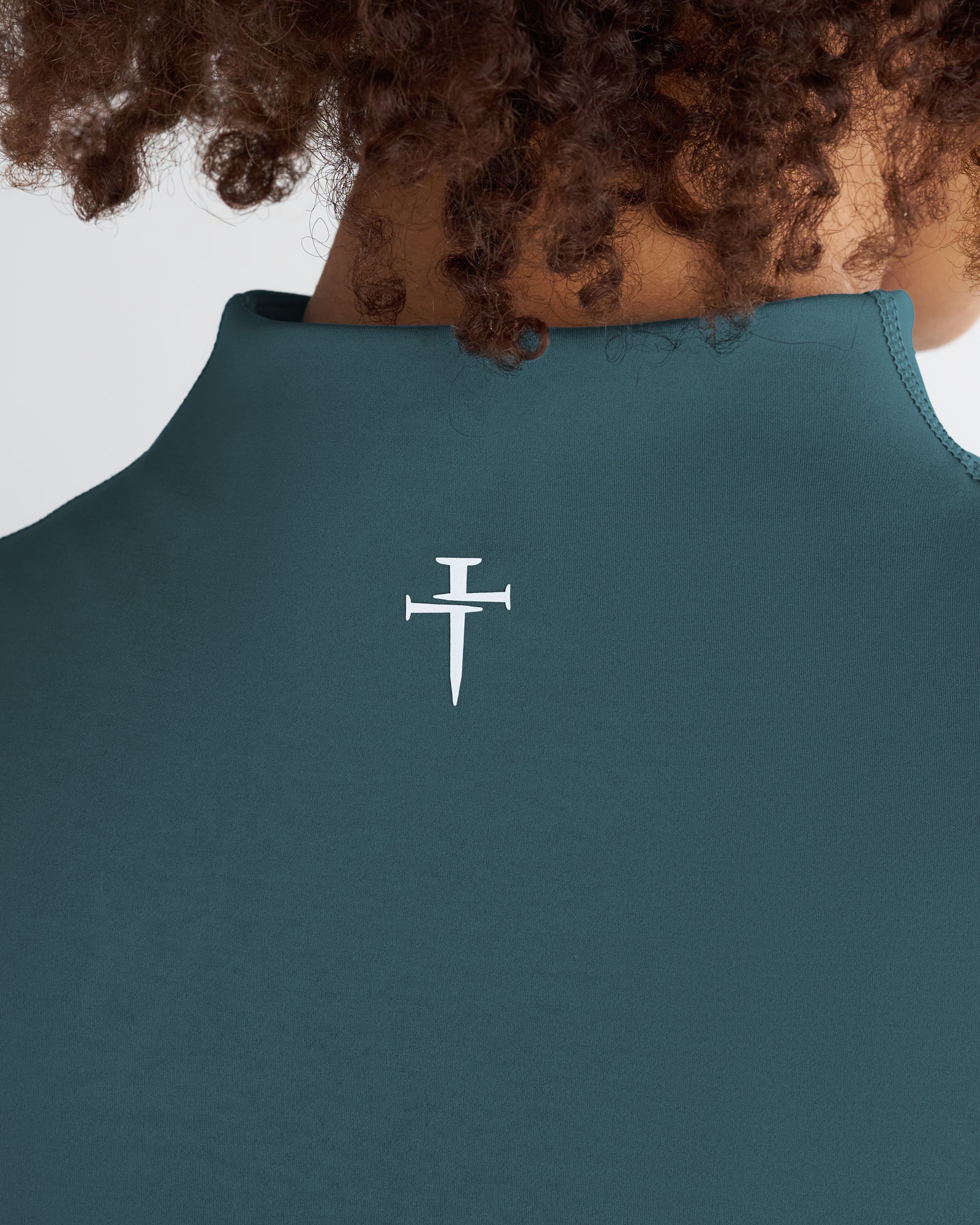 Close-up back view of Endura-Train Quarter Zip Tank in Teal showing white Three Nails logo detail at center back.