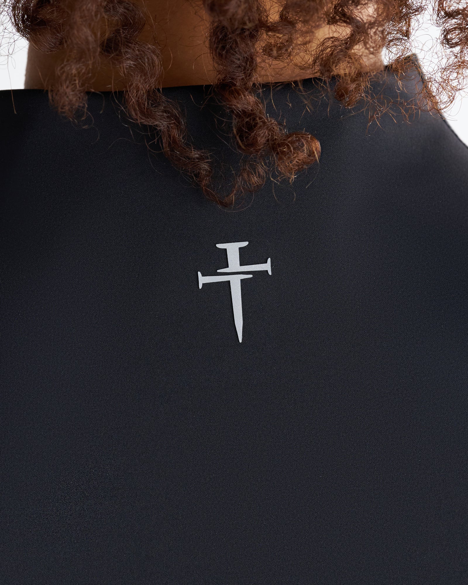 Close-up of the back neckline of the black Endura-Train Quarter Zip Tank showing the Three Nails logo print.