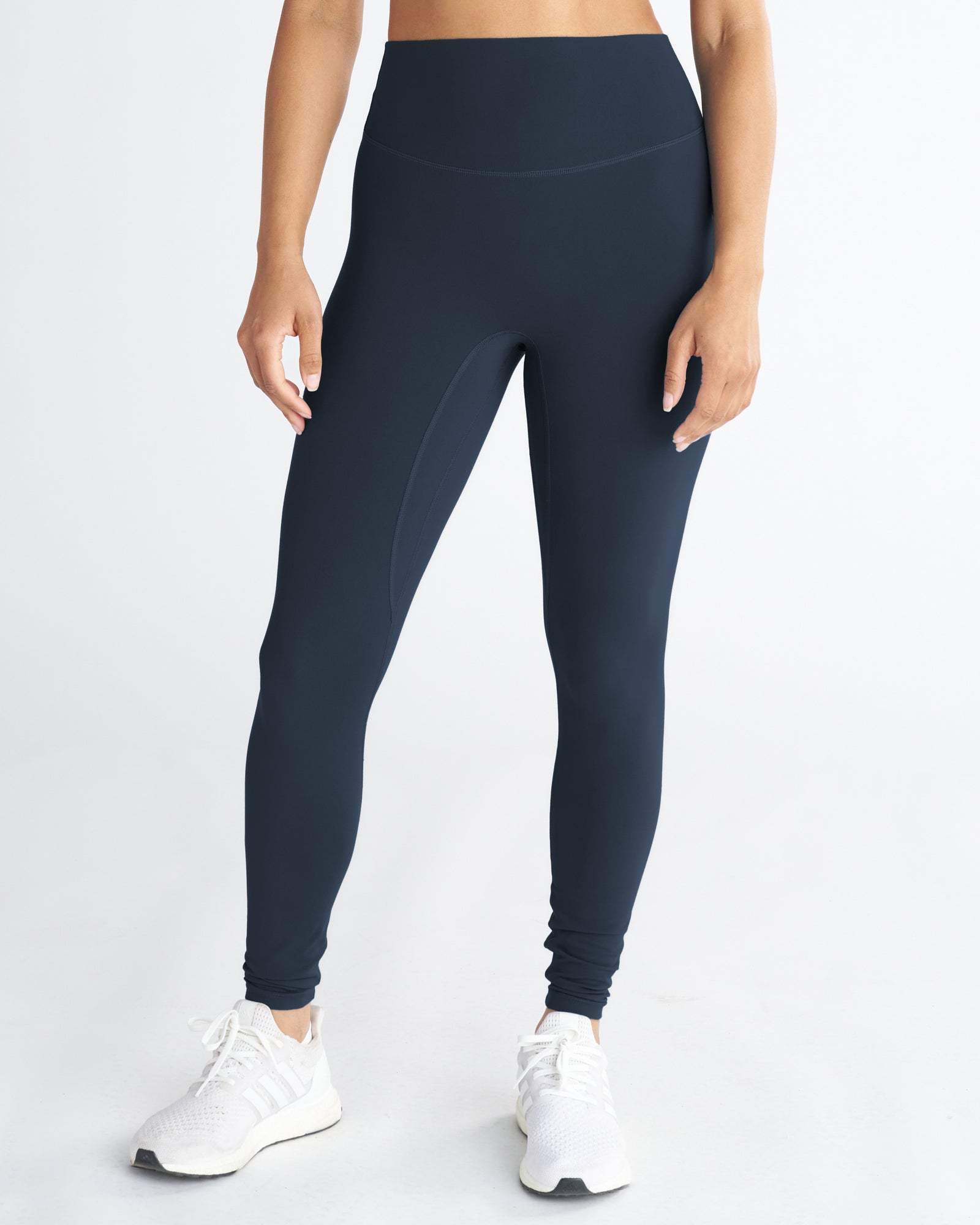 Nova Pocket Legging 27" in navy, front view on model, high waistband, full length, paired with white sneakers.