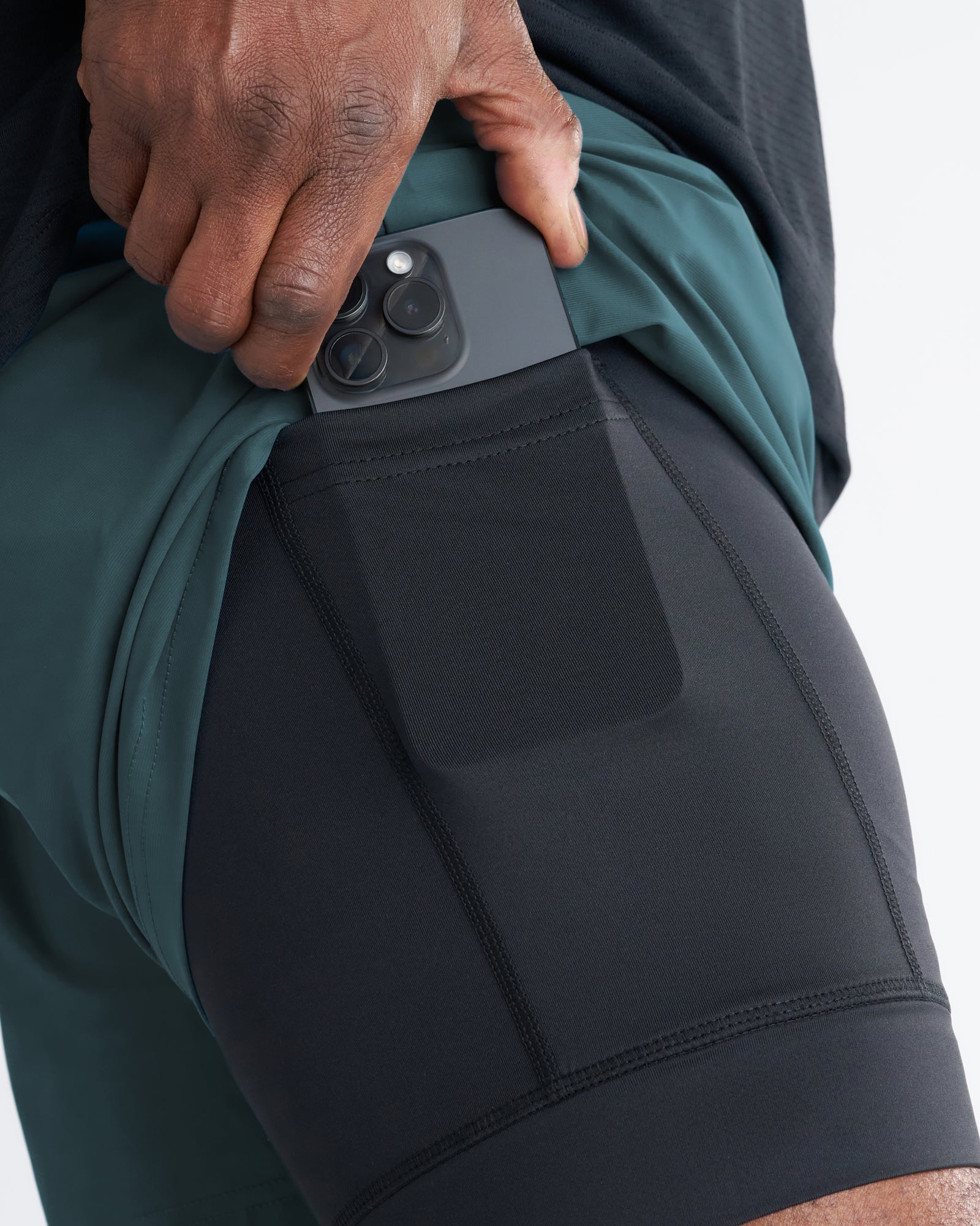 Close-up of Vapor-Lite Liner 5 Inch Short Cross in Teal showing inner liner pocket with phone being inserted.