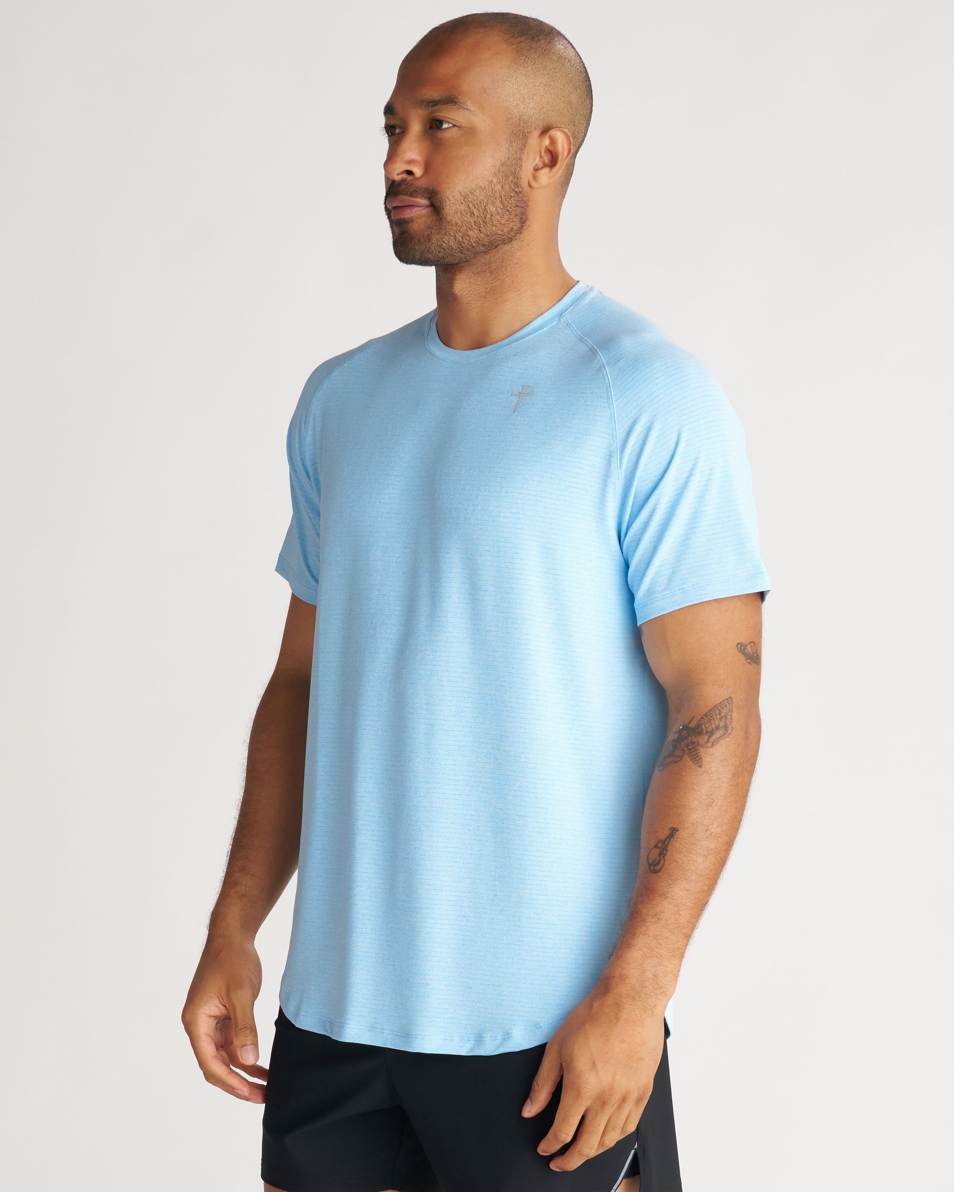 Aion-Lite Tee Cross in Sky Blue Marl on male model at a slight side angle, short sleeves, crew neck.