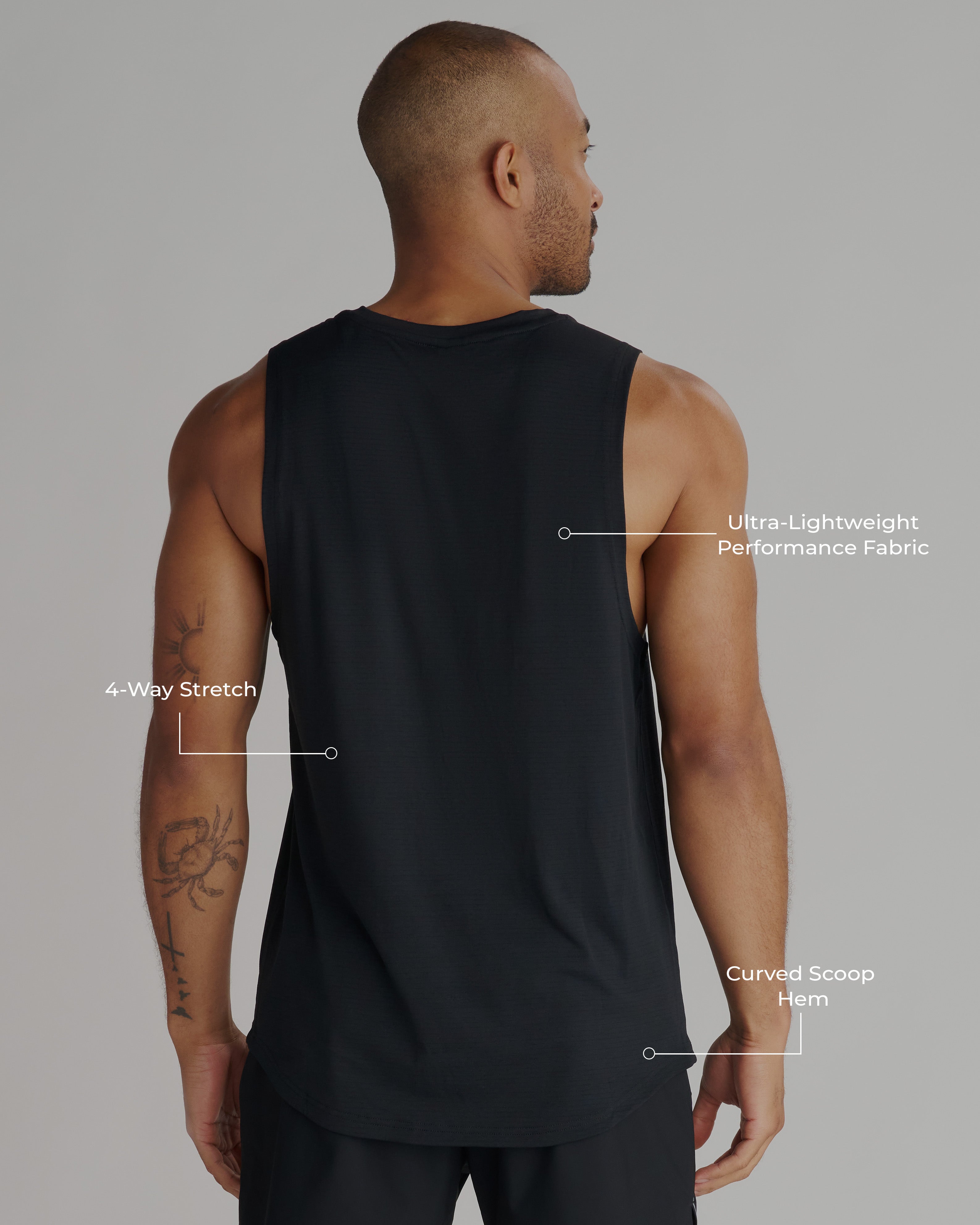 Back view of a man wearing the Aion-Lite Tank in black, showing curved hem and sleeveless silhouette.