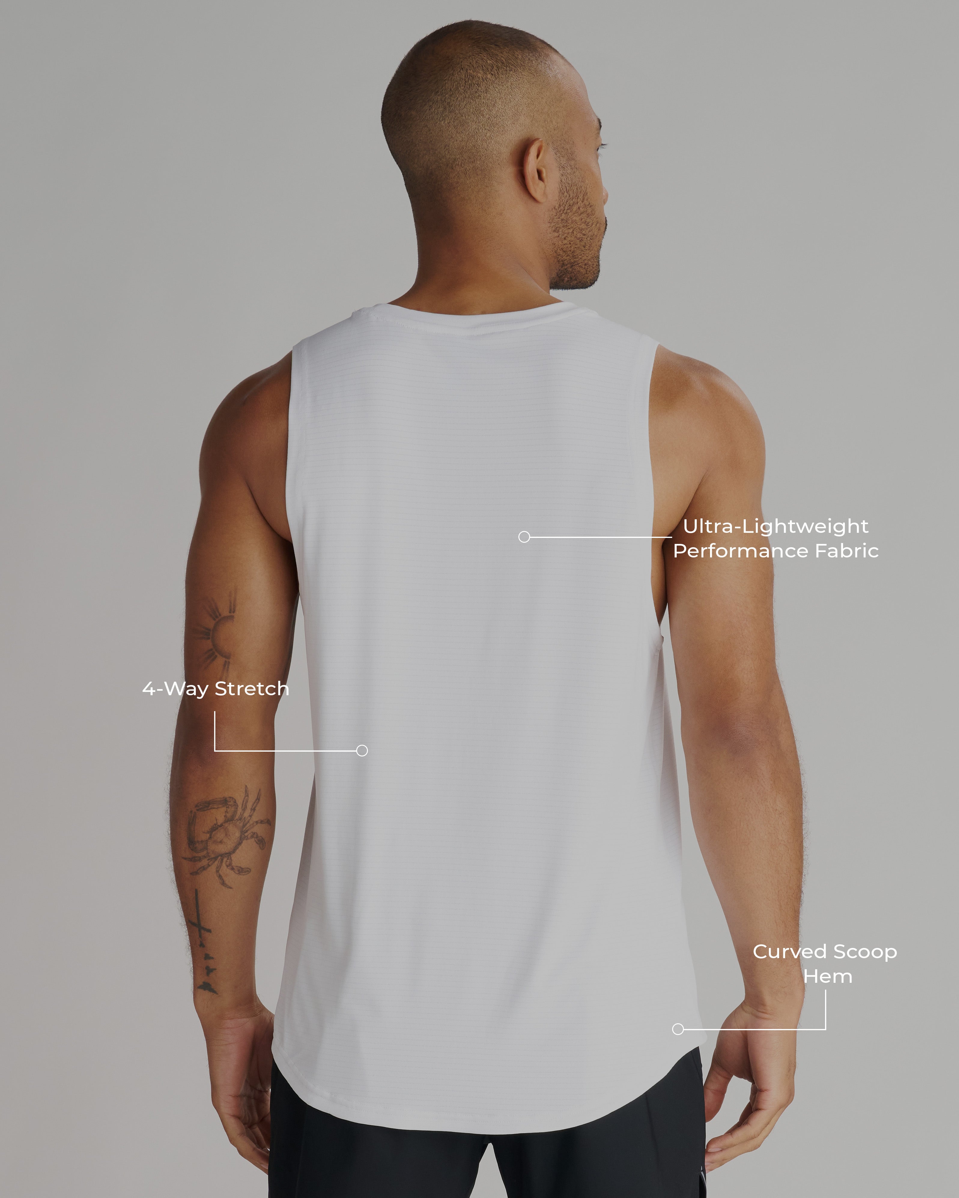 Back view of a man wearing the Aion-Lite Tank in white, showing curved hem and relaxed fit.