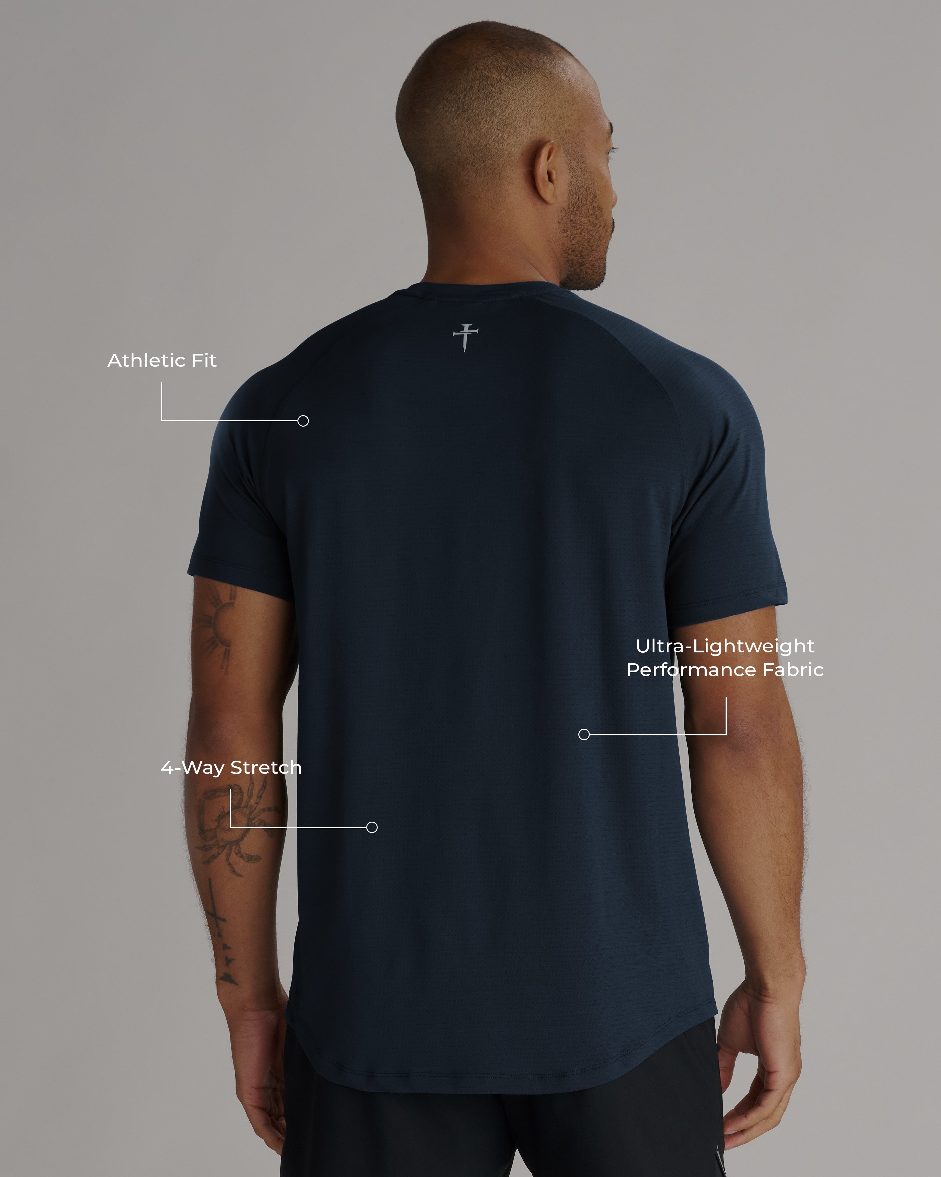 Back view of the Aion-Lite Tee Three Nails in Midnight Navy on a male model with feature callouts.