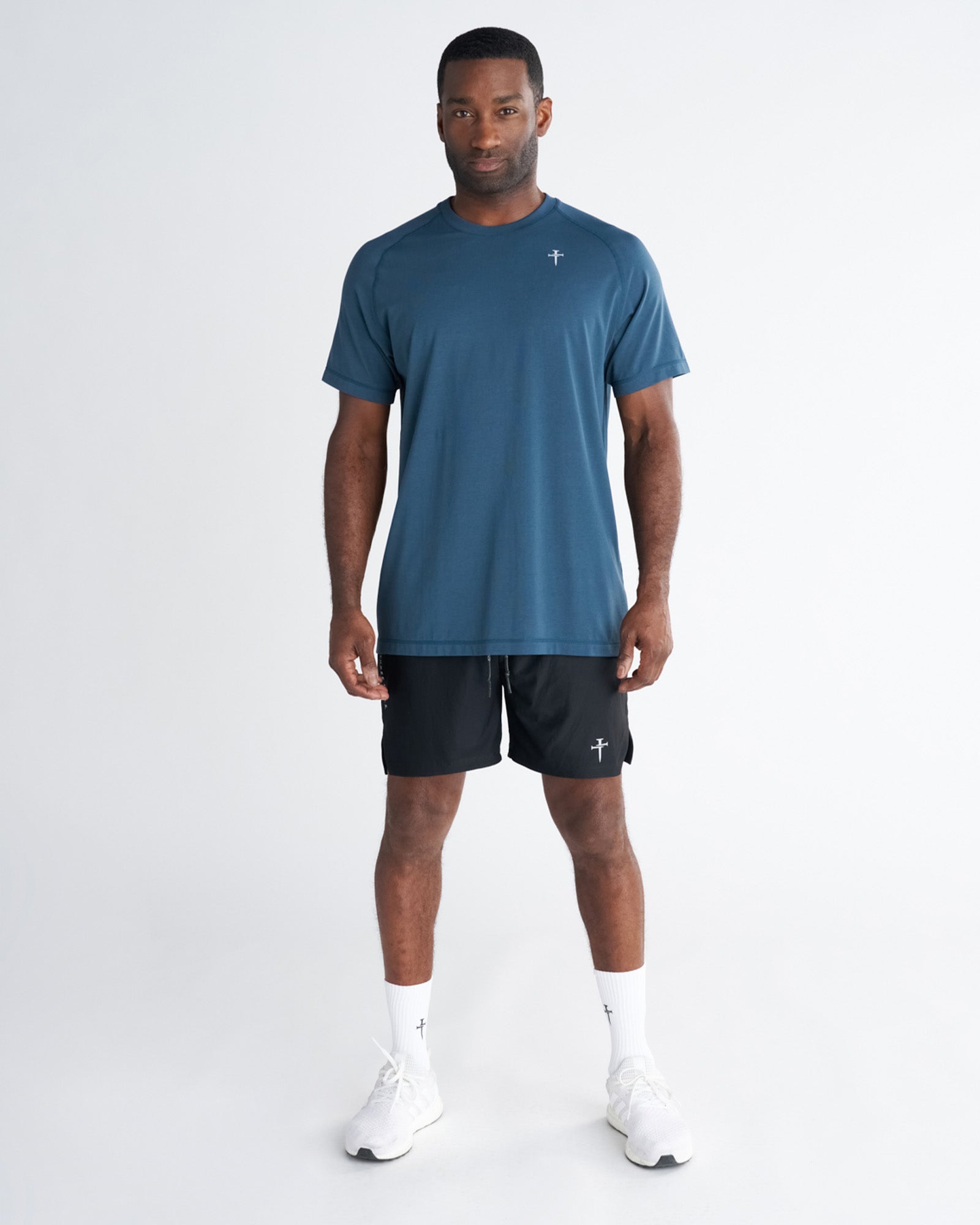 Man wearing the Core Tee in Midnight Navy, front view, paired with black shorts and white sneakers.