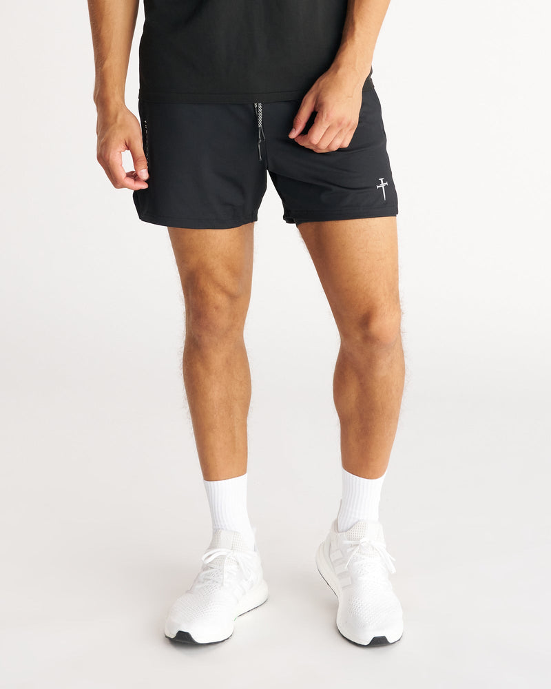 Front view of model wearing Pro-Tech 2.0 Liner 5" Short Bundle Pack in black with white sneakers.