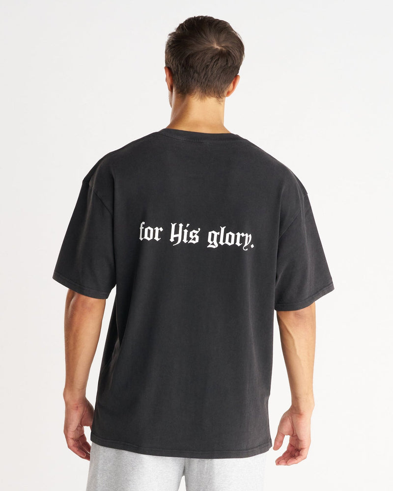 Back view of model wearing FHG heavyweight oversized tee in washed black with for His glory gothic text print.