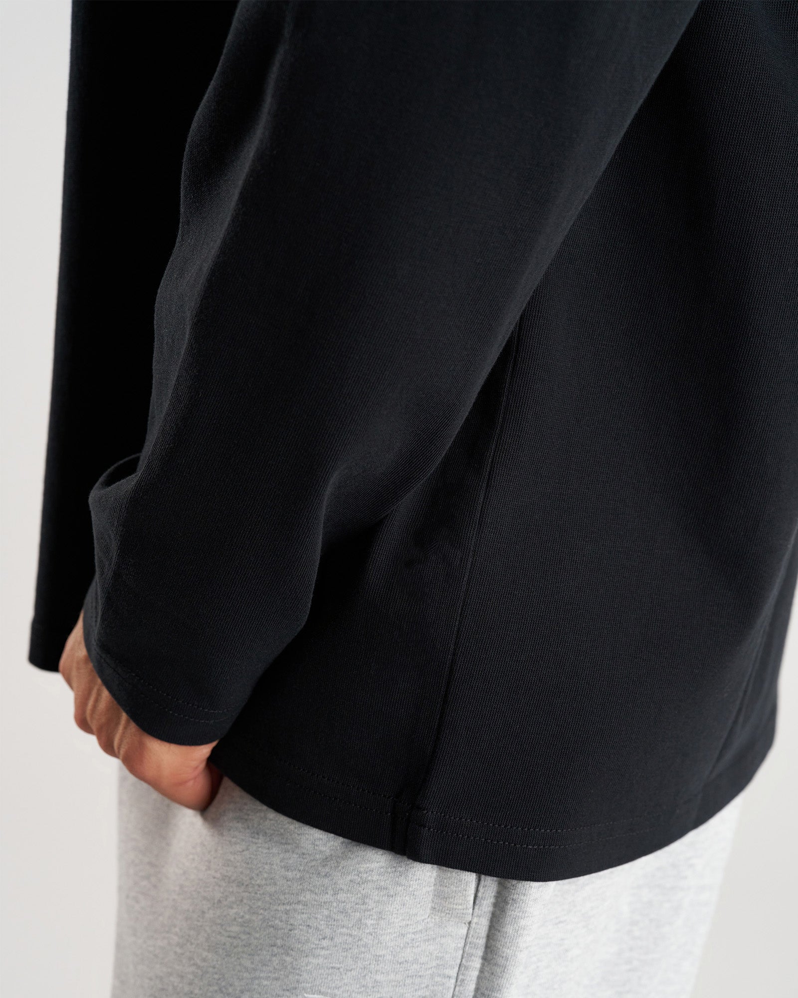 Close-up detail of black Heavyweight Cotton Oversized Long Sleeve FHG sleeve cuff and side seam construction.