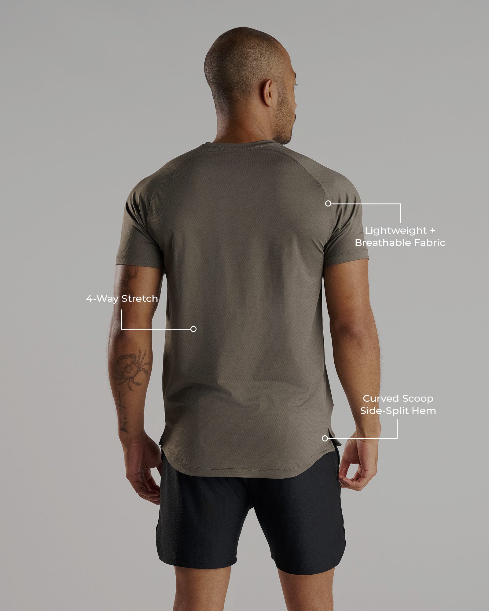 Back view of a male model wearing the Pro-Tech Tee Cross in Sage, showing curved hem and 4-way stretch fabric.