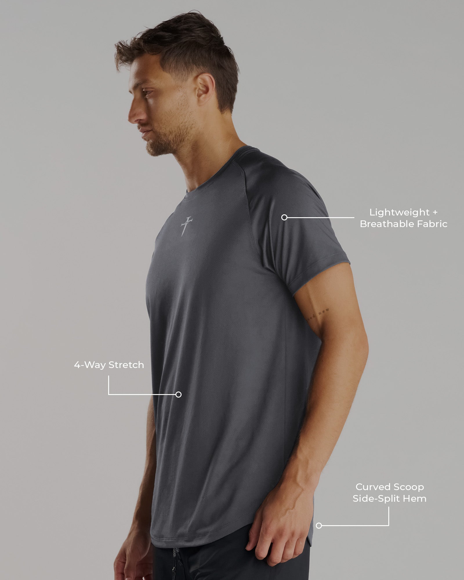 Man wearing the Pro-Tech Tee Cross in Space Grey, side angle view showing curved hem and subtle cross logo.