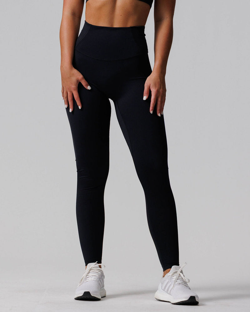 Front view of Endura-Train™ Legging Bundle Pack in black high-waist leggings worn by a model with white sneakers.