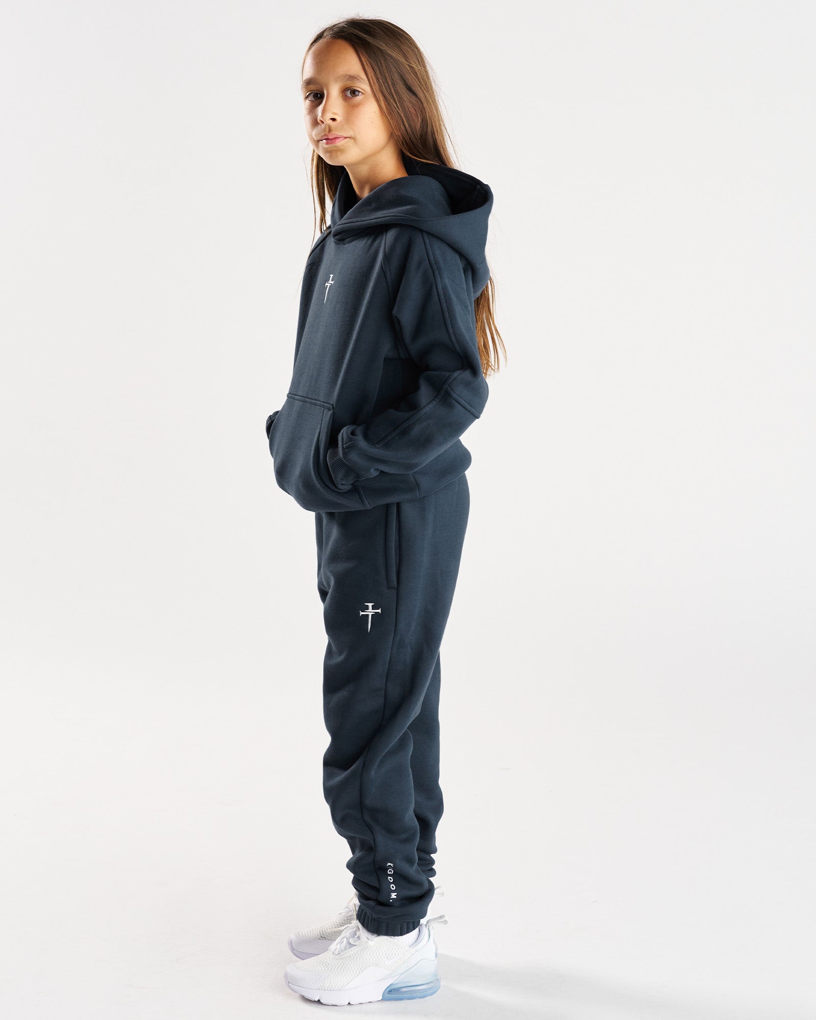 Youth Signature Fleece Hoodie in Midnight Navy shown on a child model from a side angle, paired with matching joggers.