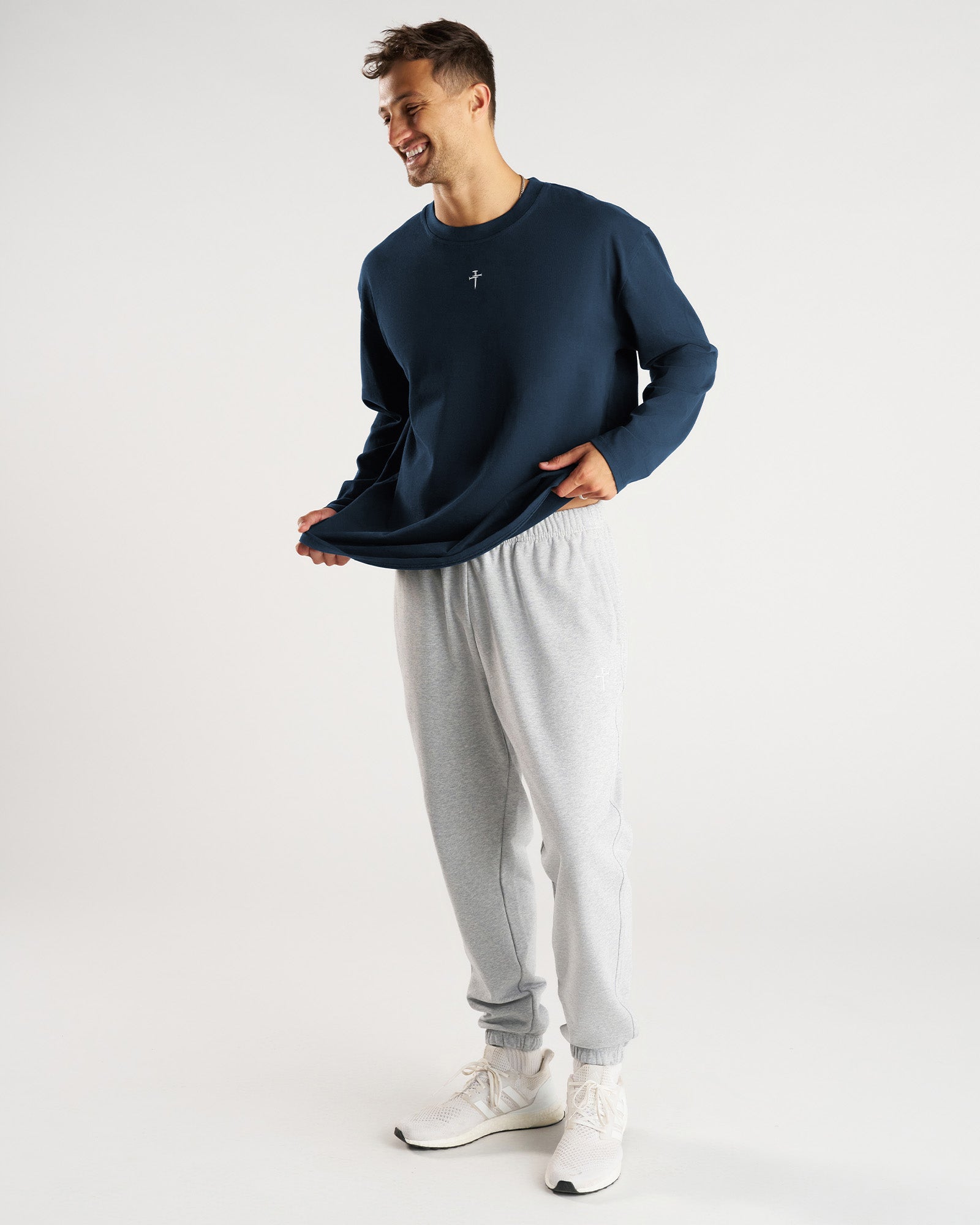 Man wearing Heavyweight Cotton Oversized Long Sleeve FHG in Midnight Navy, front view, paired with grey sweatpants.