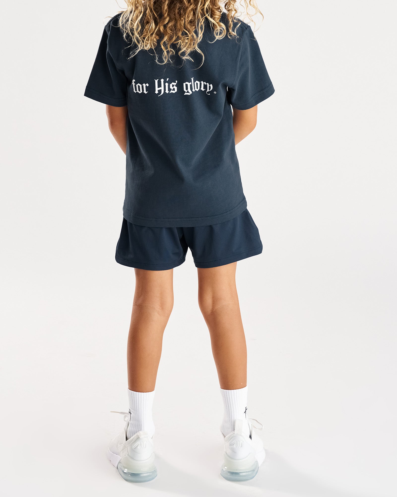 Youth Pro-Tech 2.0 Linerless Short in Midnight Navy shown from the back on a child model wearing a matching navy tee.