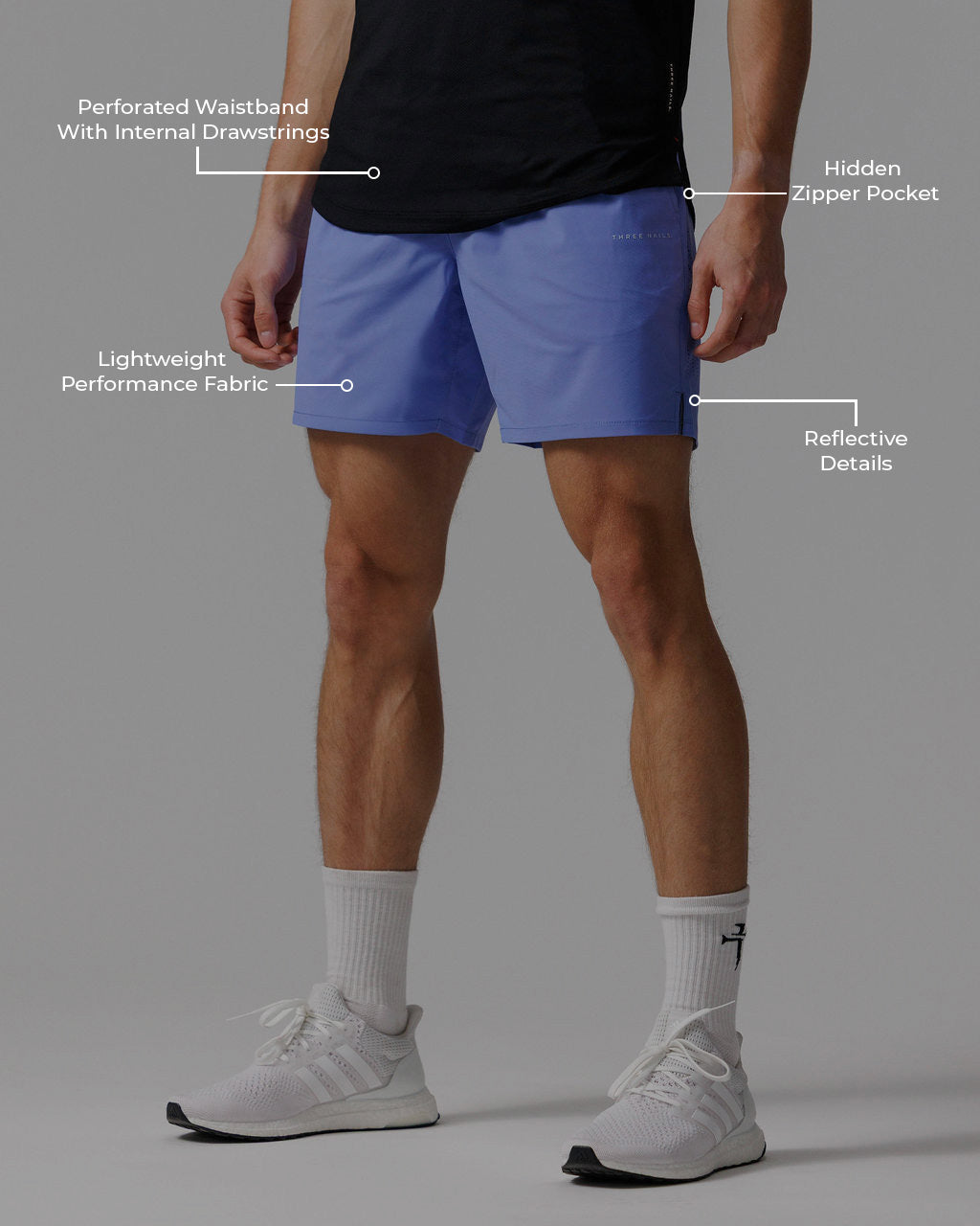 Front view of the Vapor-Lite Hybrid Short in Serene Blue on a male model, with feature callouts highlighting key design details.