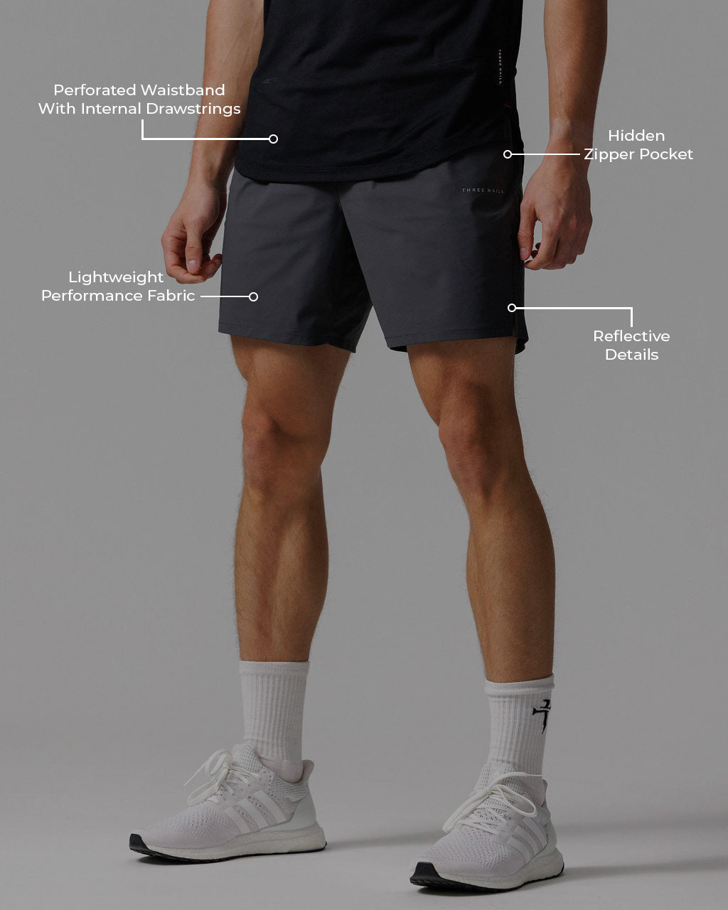 Man wearing Vapor-Lite Hybrid Short in Space Grey, front view, with feature callout labels visible.