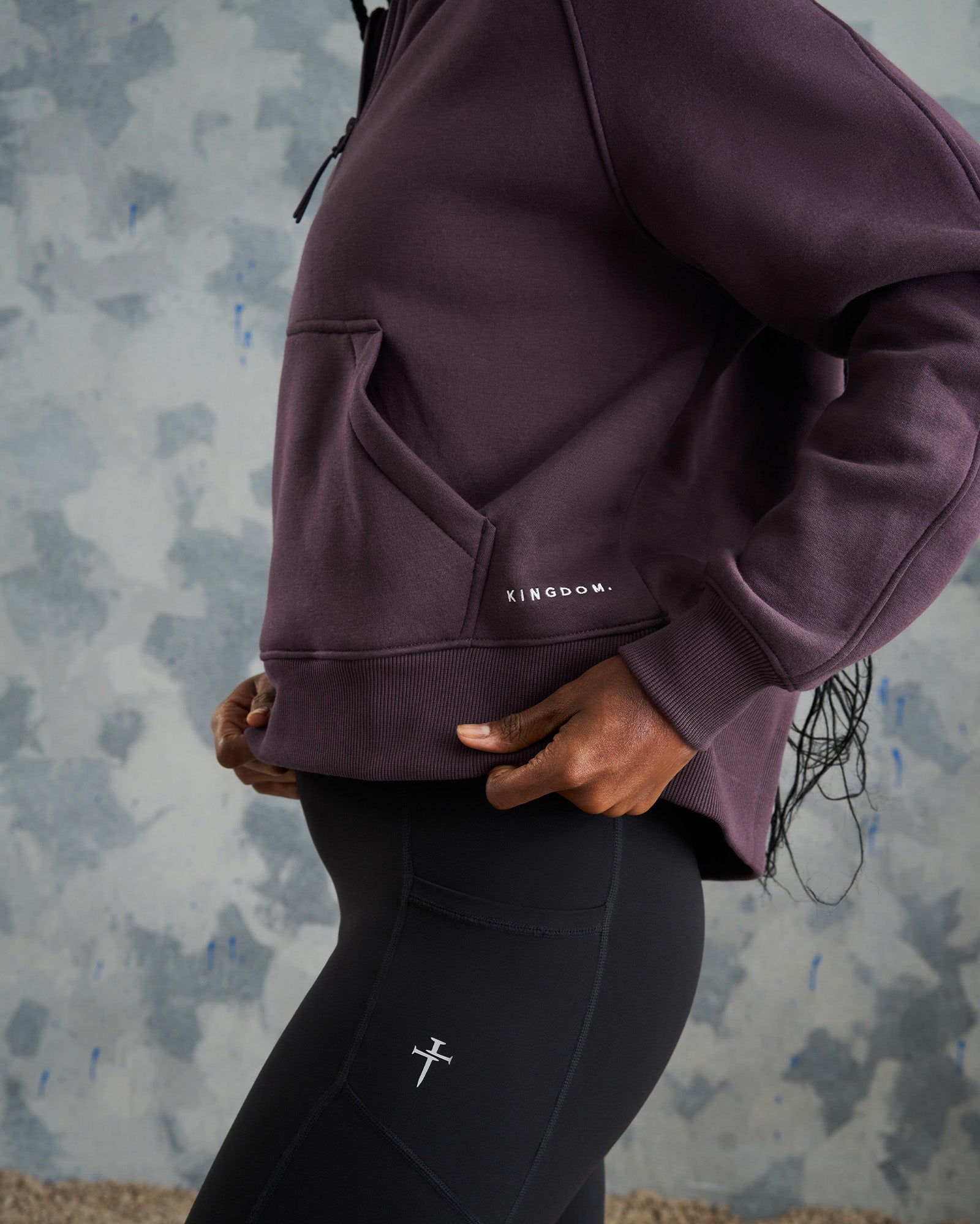 Close-up side angle of the Women's Signature Fleece Half-Zip Hoodie in Nightshade showing the Kingdom logo and kangaroo pocket detail.